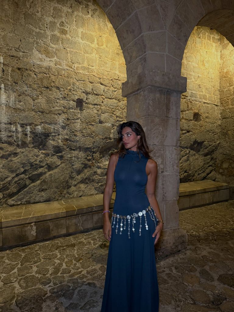 Susana Molina con vestido azul sin mangas y cuello alto, con cinturón de cuentas