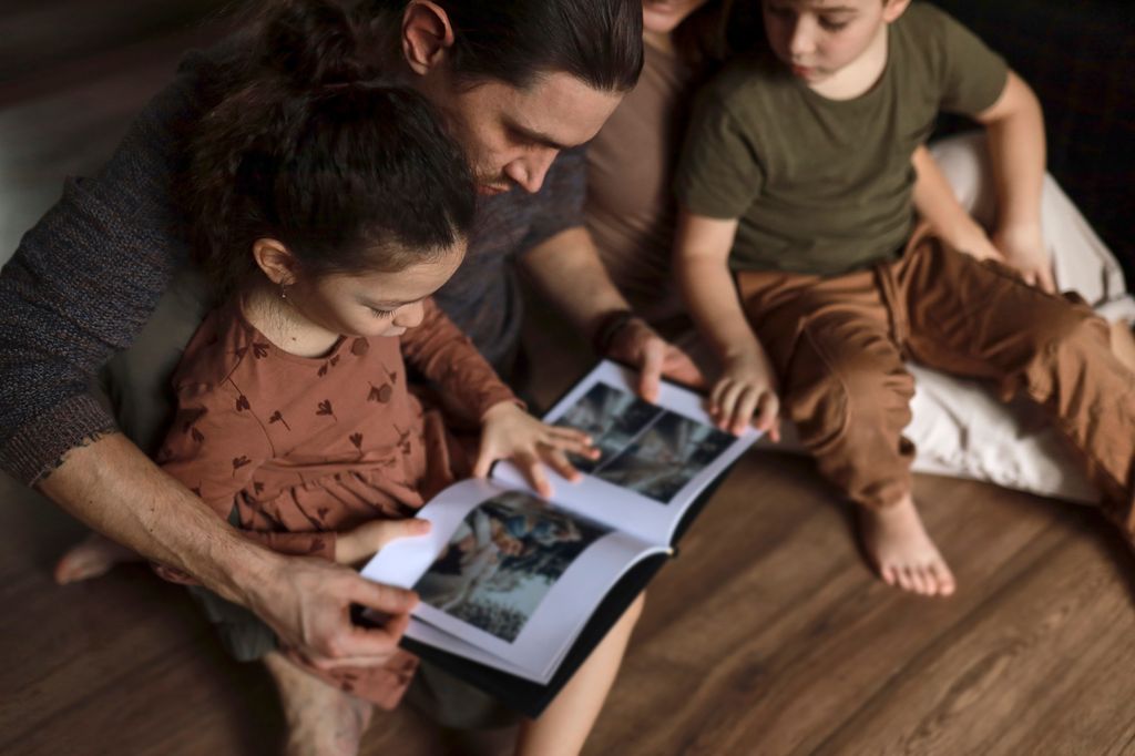 Padre con sus hijos viendo un álbum de fotos