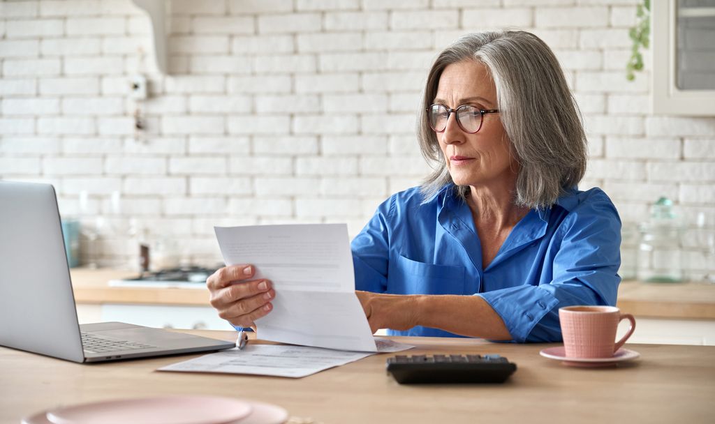 Una mujer jubilada ojeando papeles 
