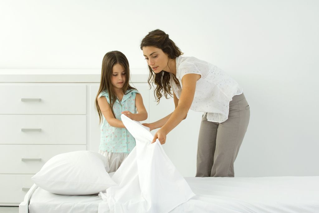 madre e hija haciendo la cama juntas