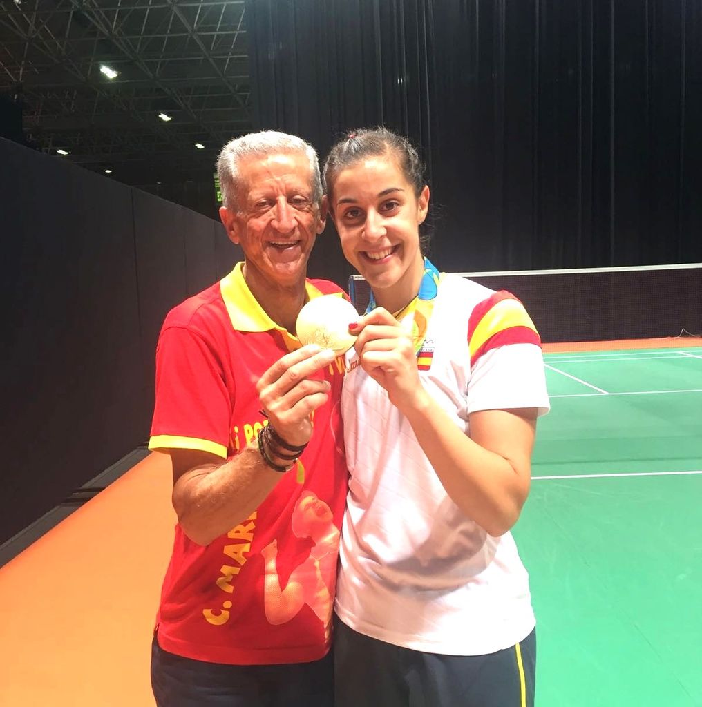 Carolina Marín junto a su padre mostrando una medalla de oro