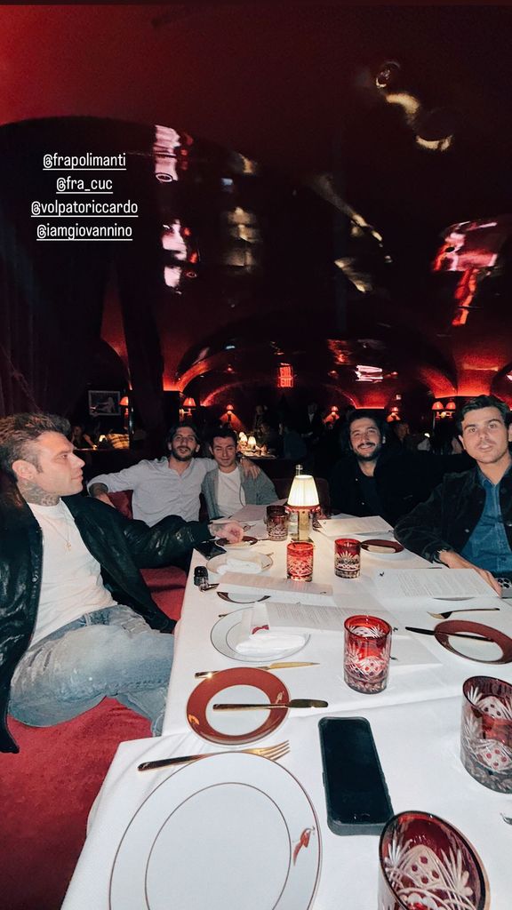 Plano medio de Fedez con amigos en un restaurante