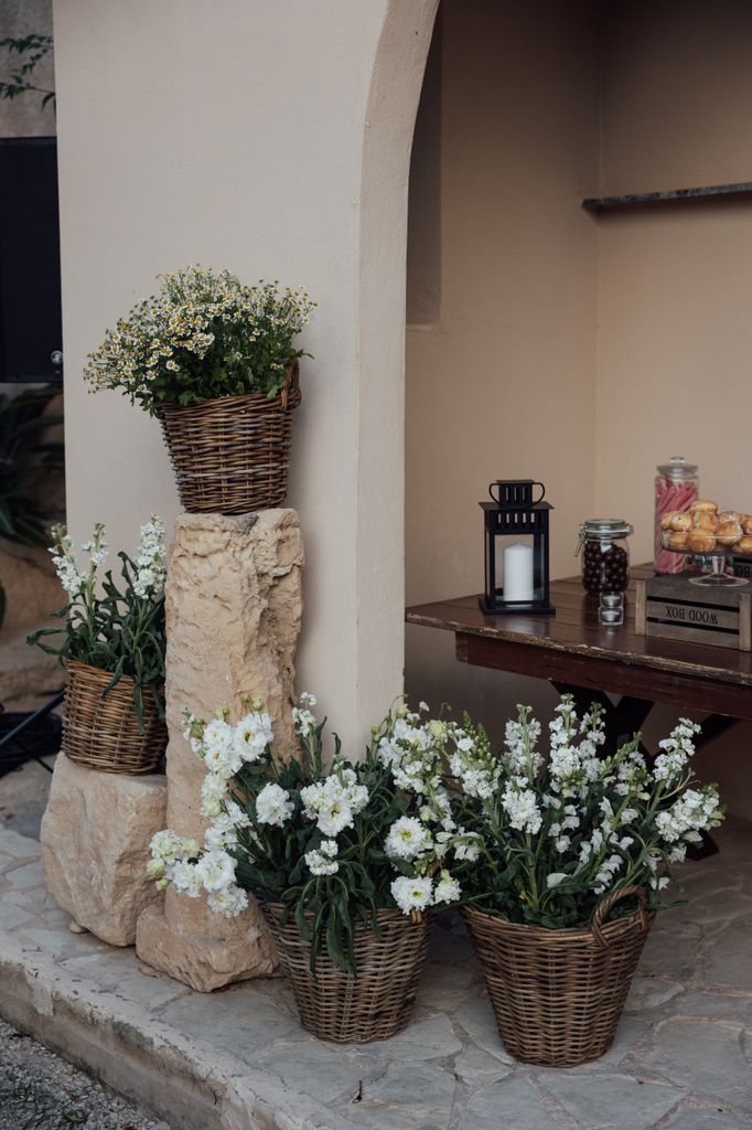 Rincón dulce decorado con cestos de flores blancas