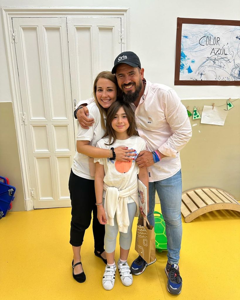 Isa con sus padres y su cuento en la mano