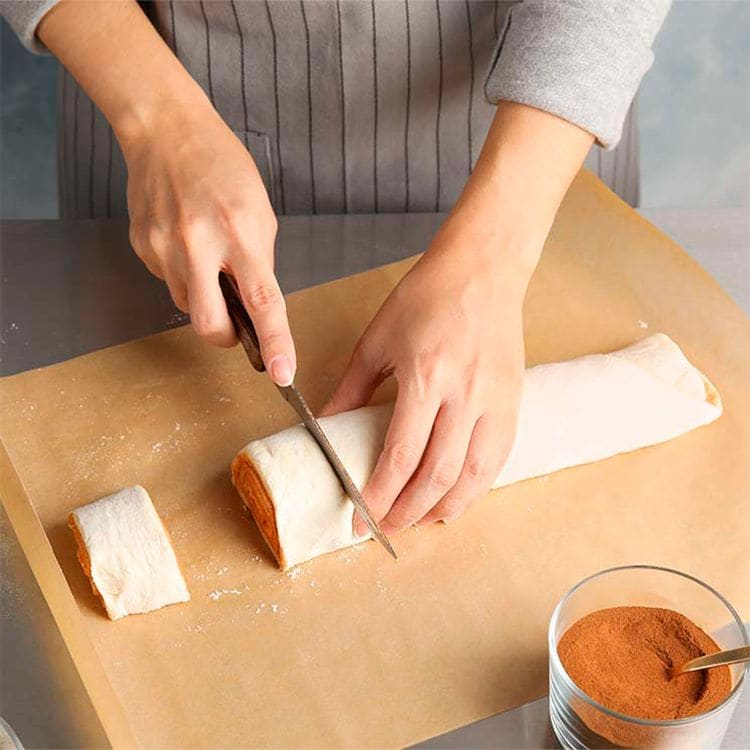 Cortando la masa en porciones para hacer 'cinnamon rolls'