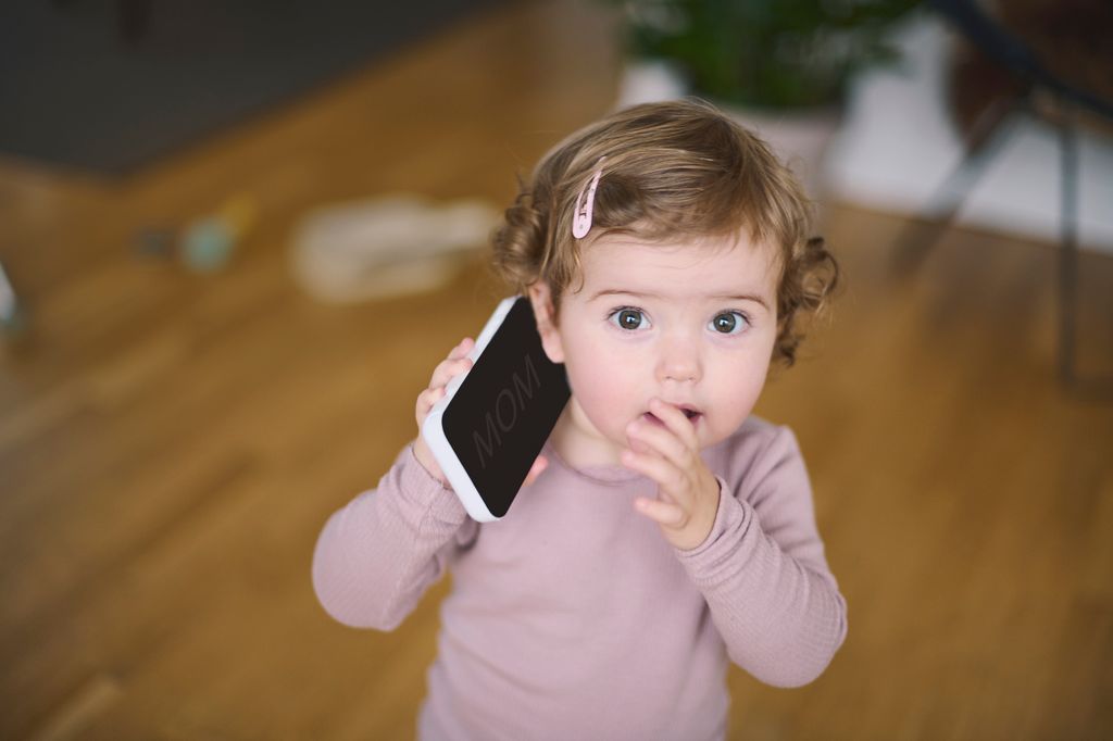 Una niña pequeña con un móvil