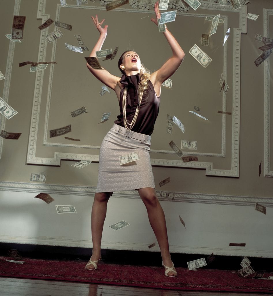 Mujer tirando billetes a su alrededor