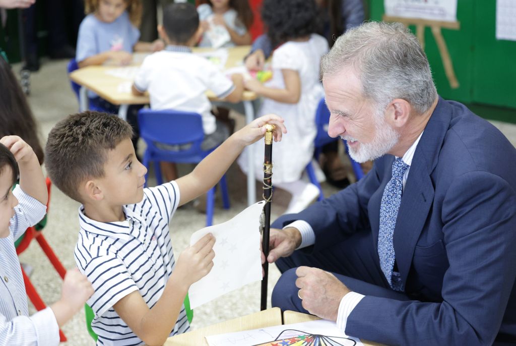 El divertido momento del bastón del rey Felipe con un niño