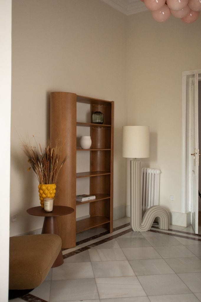 Recibidor con estantería de madera y lámpara de pie