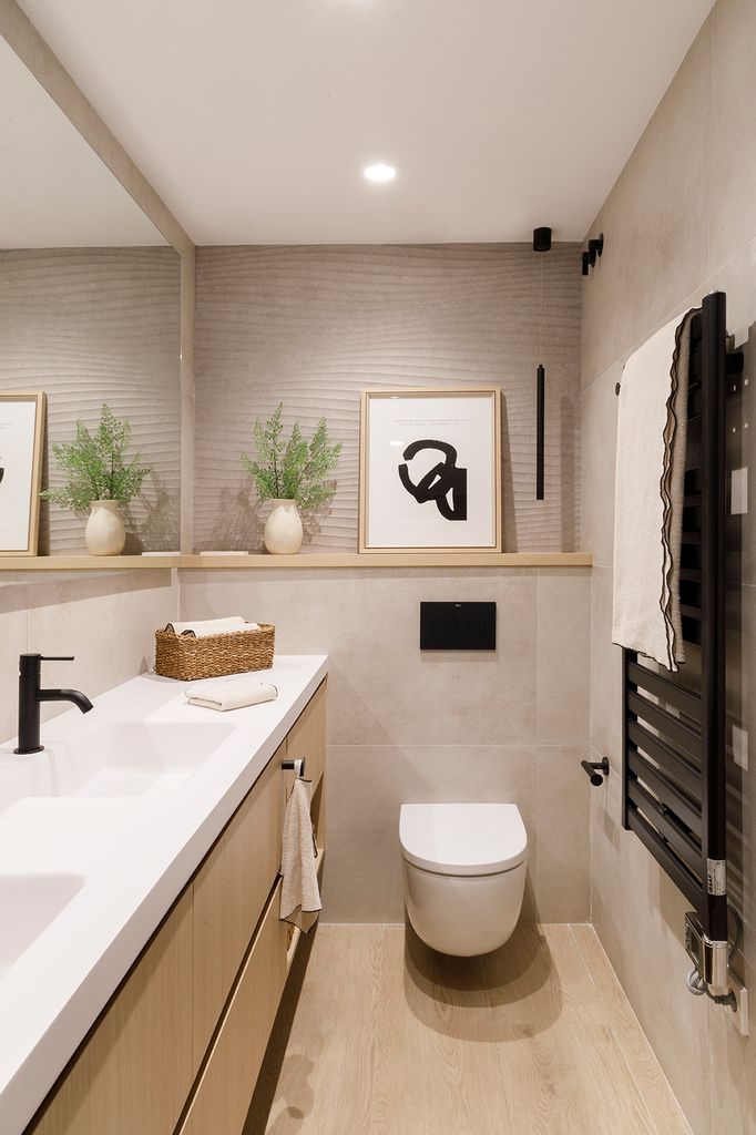 Cuarto de baño con cisterna empotrada y repisa en la pared de inodoro