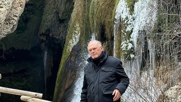 Plano medio de Pedro Piqueras posando con una cascada de fondo