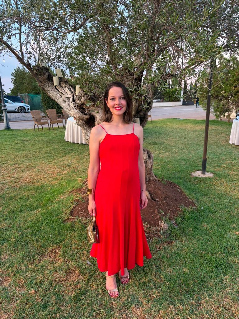 Regina Navarro, coordinadora de Novias en ¡HOLA!, con un impecable vestido rojo vibrante que acaparaba todas las miradas.