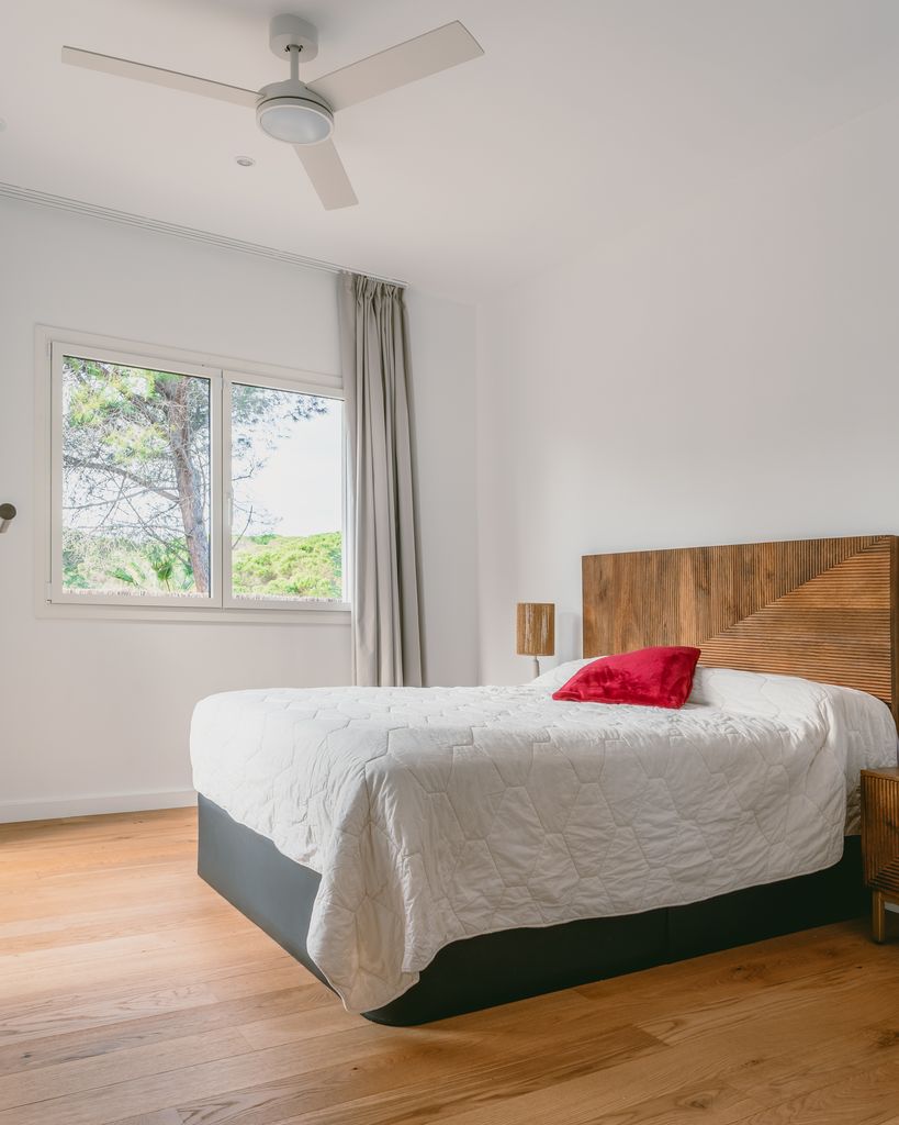 Dormitorio de una vivienda diseñada con criterios de bioconstrucción, una estancia que cuenta con un ventilador de techo