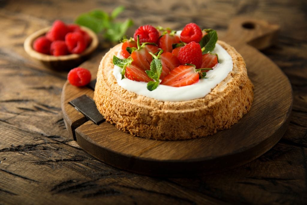 Tabla de madera con bizcocho de yogur con chocolate blanco y fresas