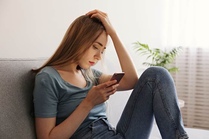 mujer preocupada mirando al móvil