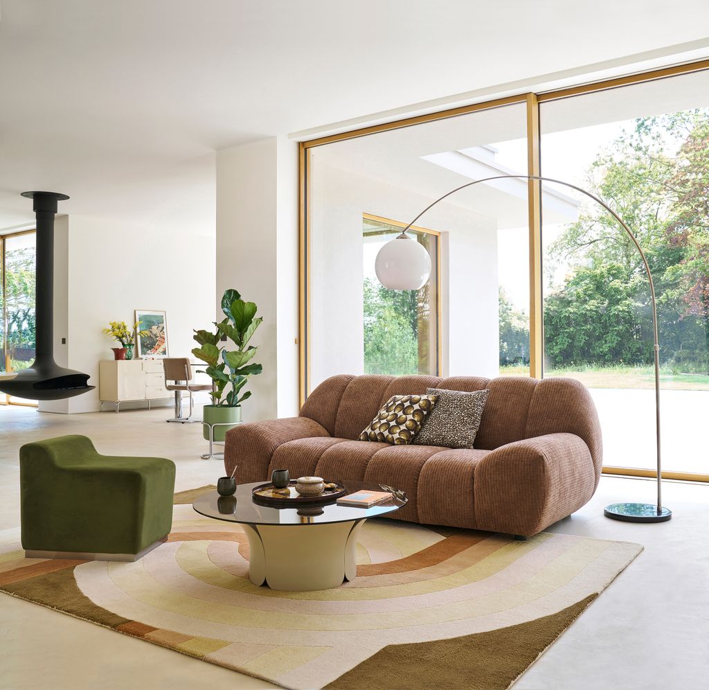Salón con sofá terracota y sillón verde                      