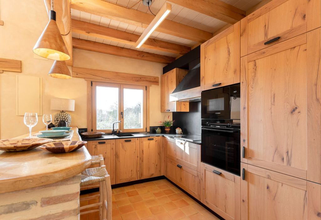 Cocina en madera con una barra tipo península también de este material natural
