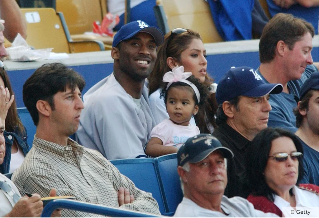 Kobe Bryant está sentado con Natalia y Vanessa durante el partido de los Los Angeles Dodgers contra los New York Yankees en el Dodger Stadium, el 20 de junio de 2004