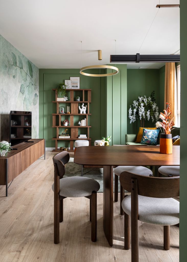 Salón verde con muebles de madera oscura