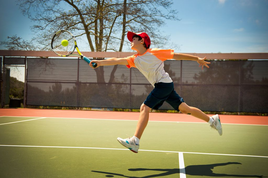 niño jugando al tenis