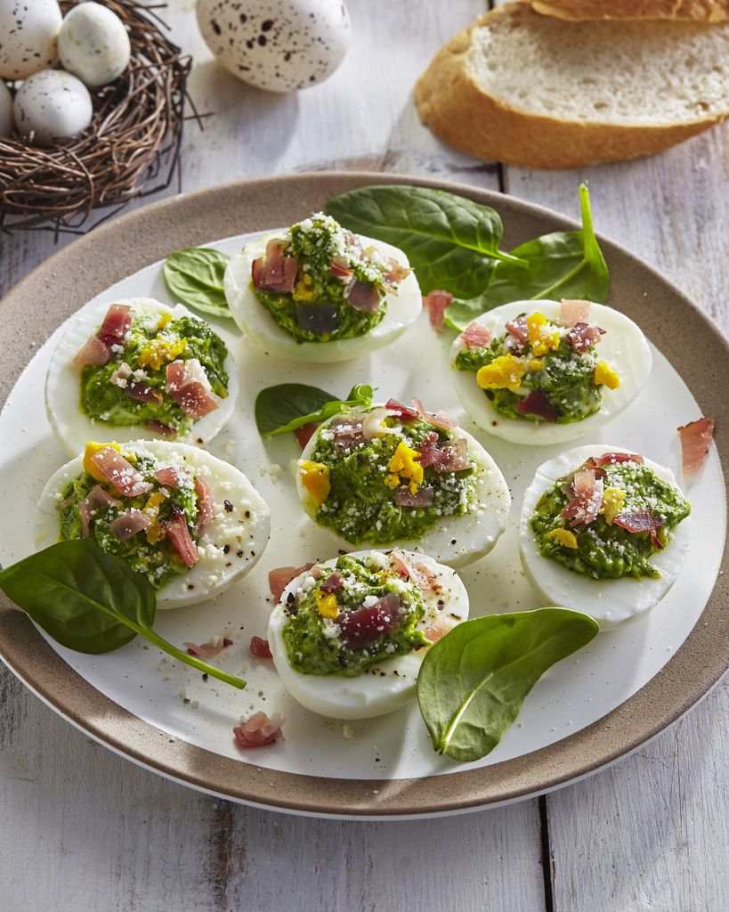 Huevos rellenos de crema verde con bacon.