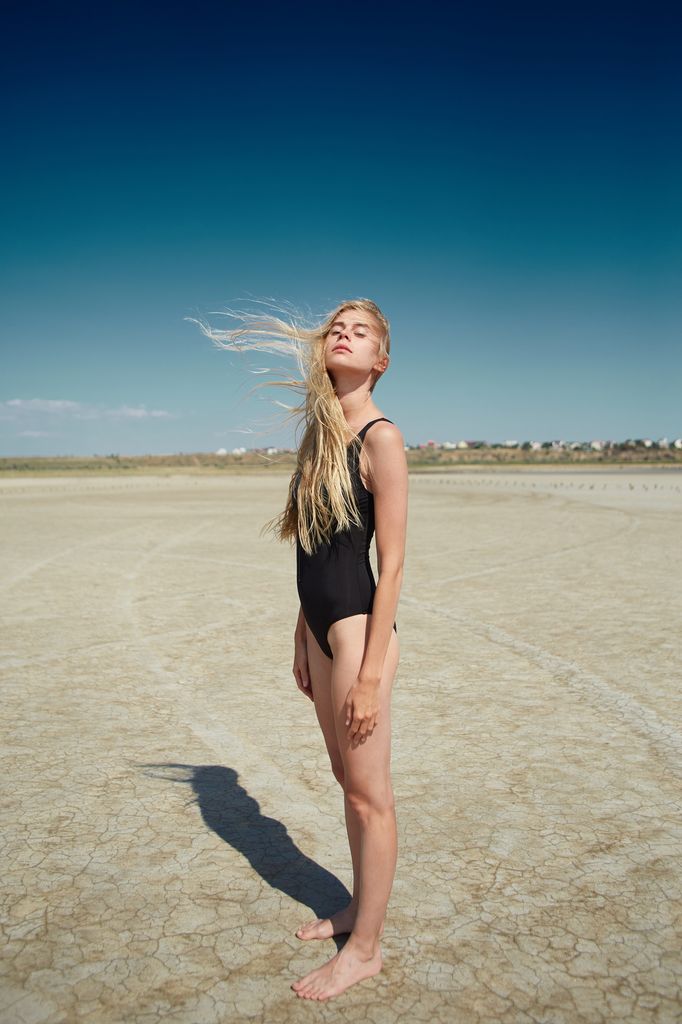 Mujer joven en la playa pensando 
