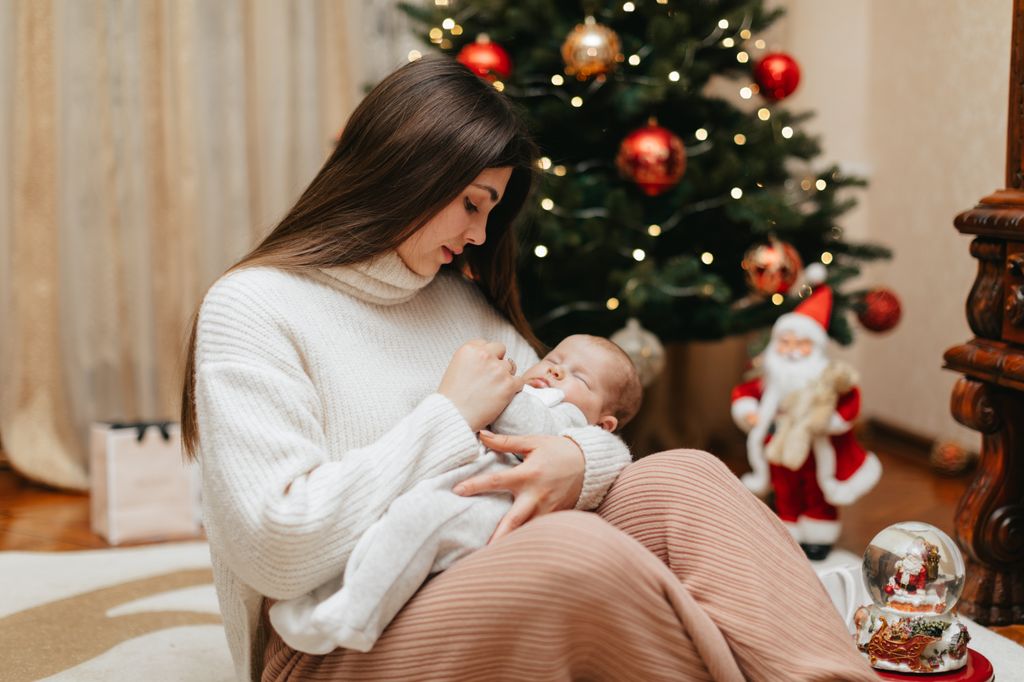 Madre con recién nacido dormido en brazos
