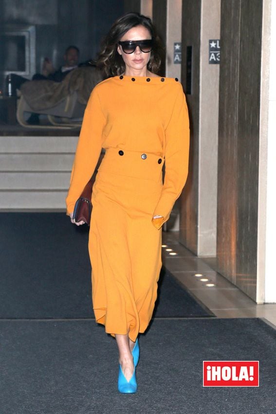 Victoria Beckham con vestido amarillo y hooties azulados