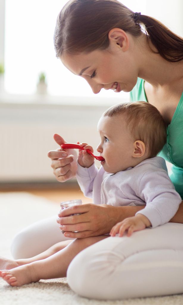 Bebé comiendo en brazos de su madre