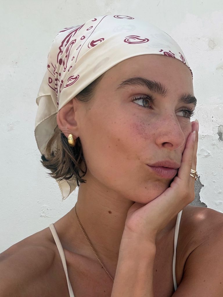 Vera van Erp en primer plano sobre fondo blanco y pañuelo estampado en la cabeza