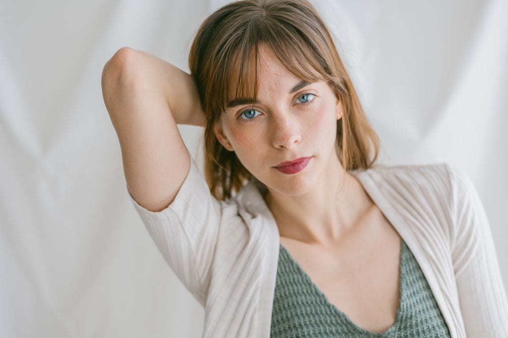 Mujer de ojos azules mirando a cámara callada y tranquila