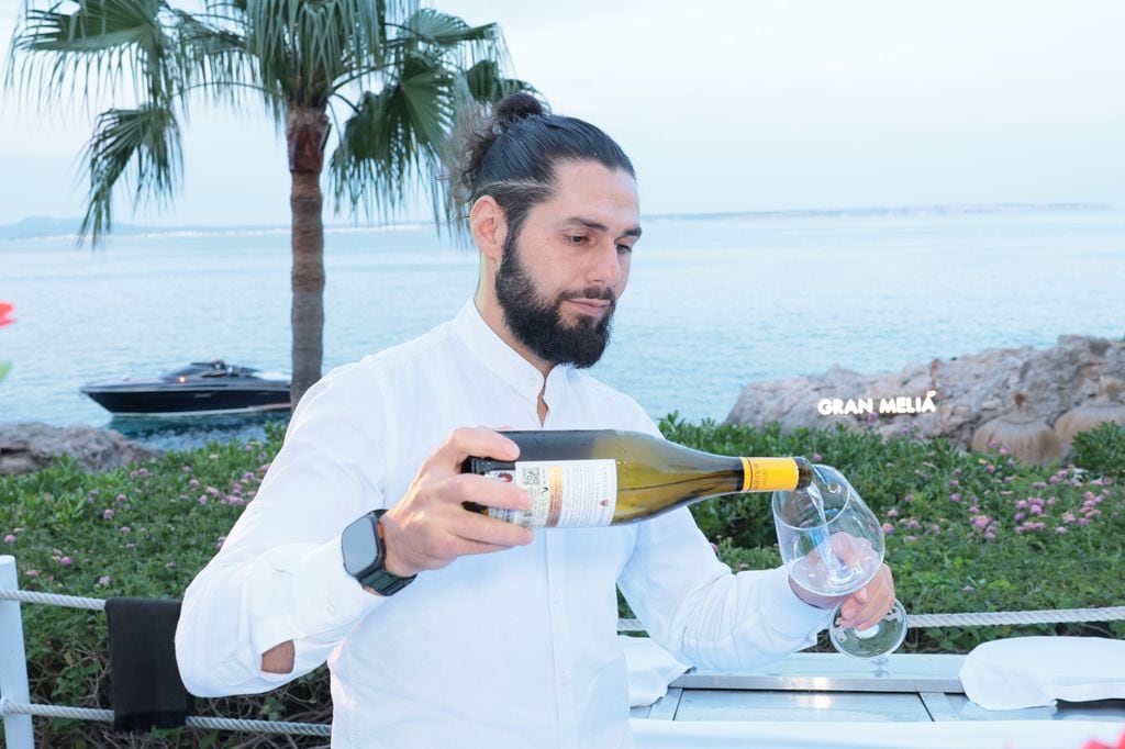 Un camarero sirviendo una copa de vino