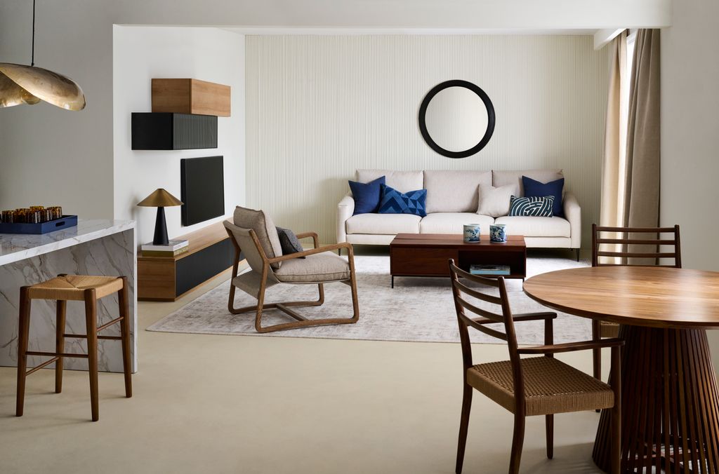 Salón con sofá blanco y butaca de madera