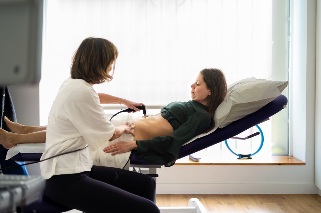 Fisioterapeuta con un tratamiento de radiofrecuencia para el suelo pélvico en el posparto