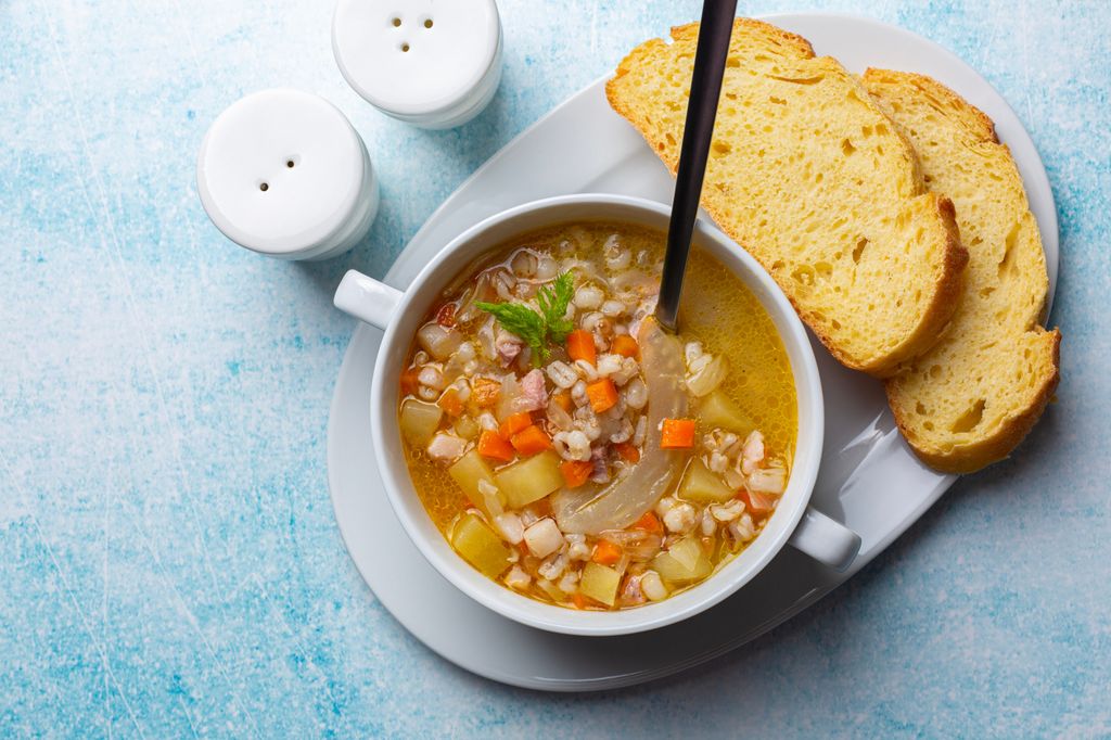 Sopa de verduras y cebada con rebanadas de pan