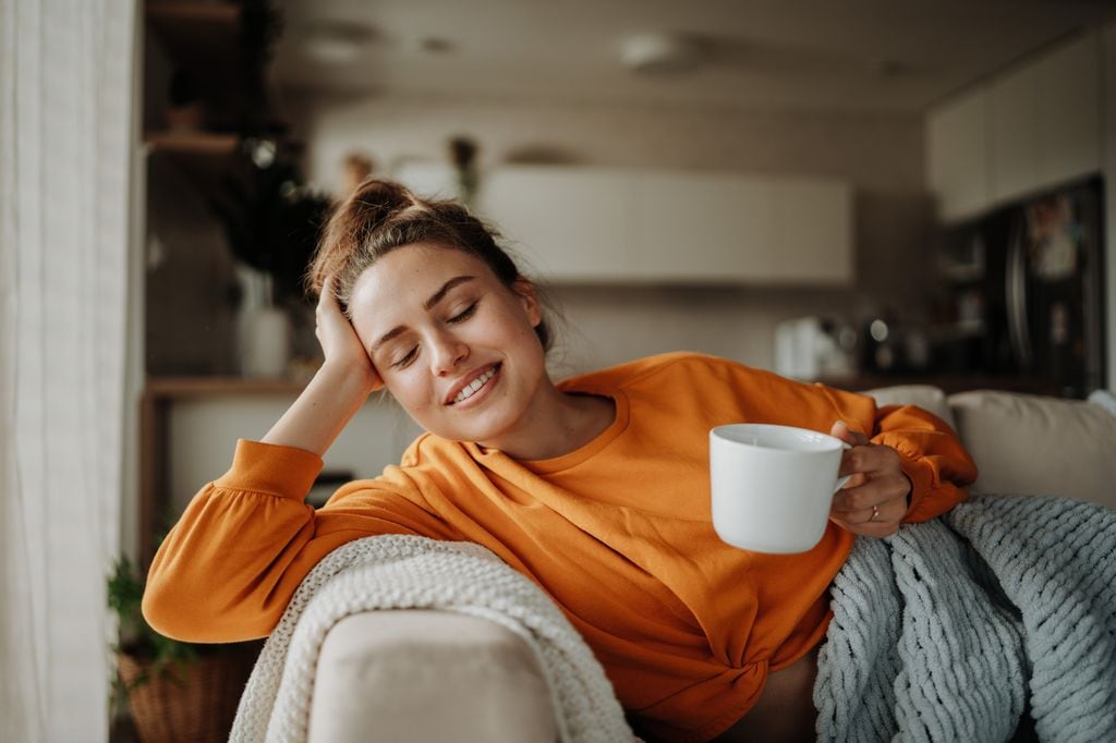 Mujer tomando té en el sofá 
