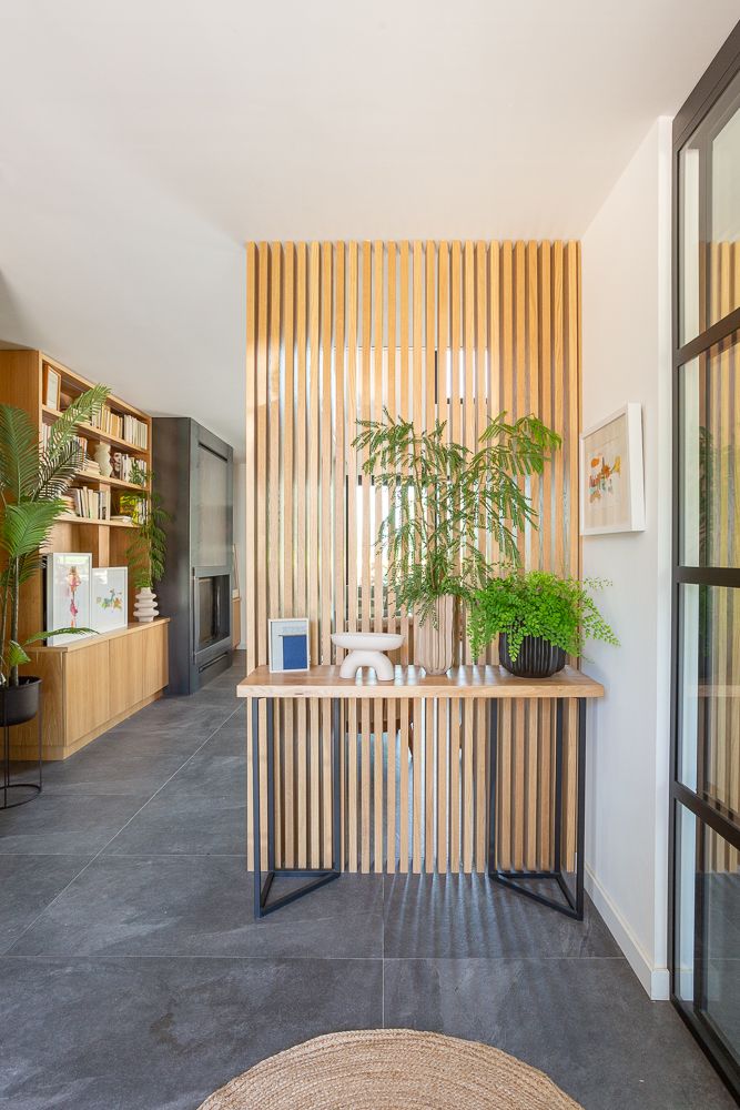 Recibidor separado del salón por palillería de madera