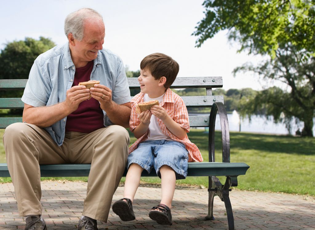 niño con su abuelo tomando la merienda en el parque