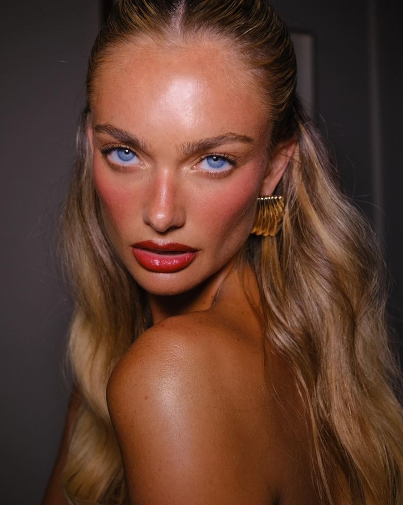 Lilia Rose en primer plano con maquillaje natural centrado en las mejillas y labios rojos