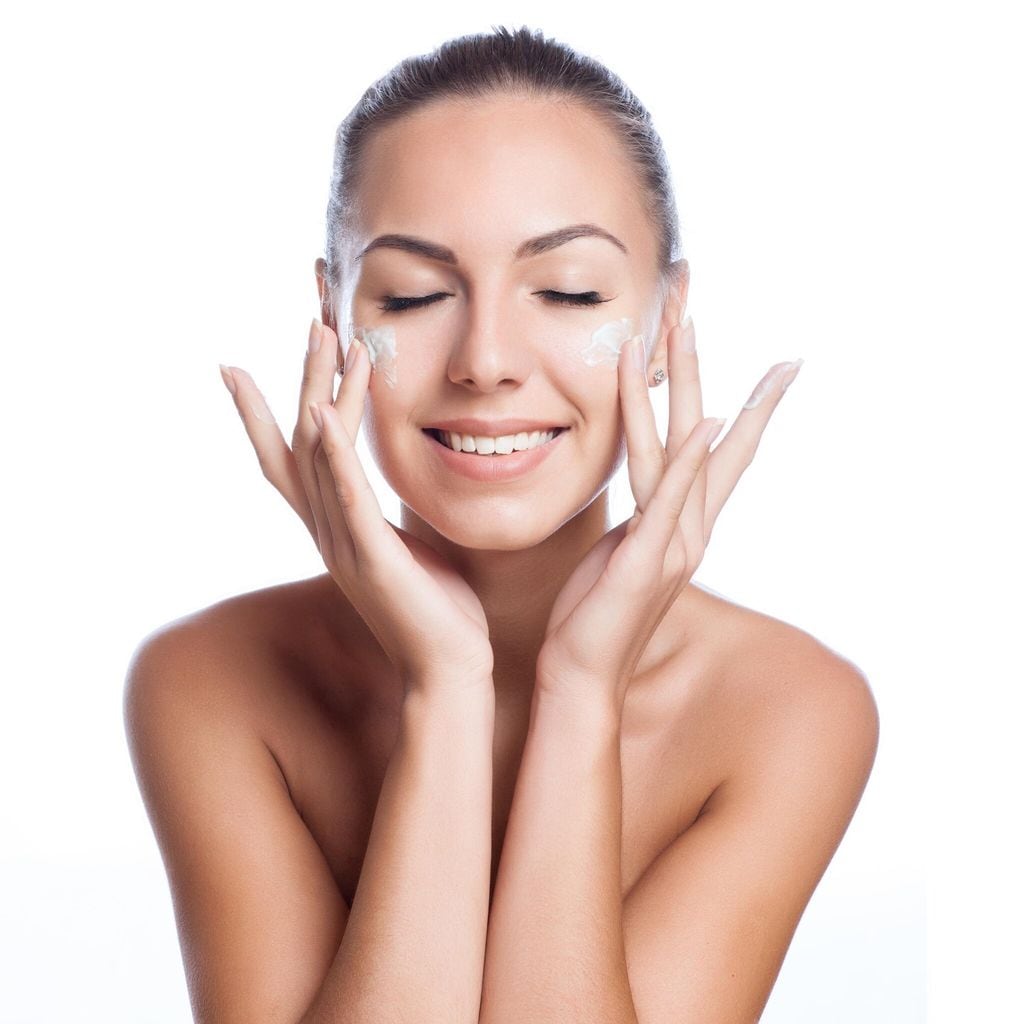 Mujer aplicando crema en su rostro
