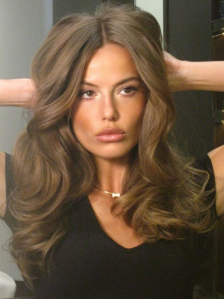 Primer plano de la modelo Alyona Lozovaya con pelo ondulado y camiseta negra