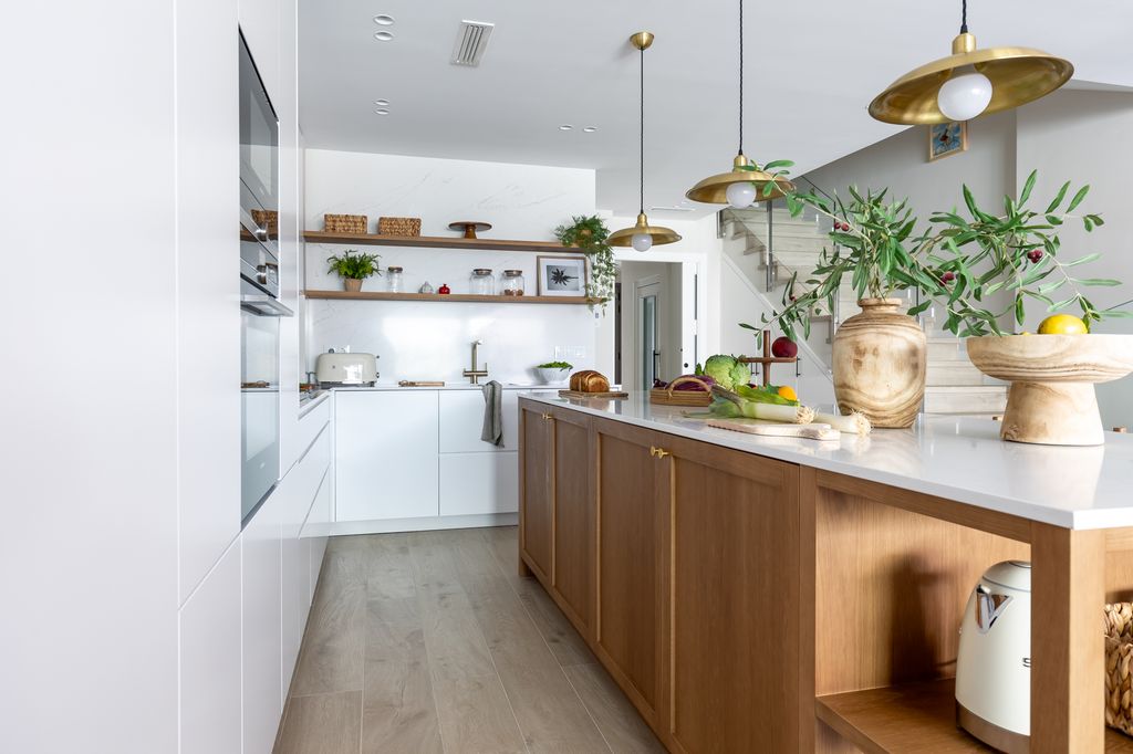 Cocina con isla de madera y muebles blancos