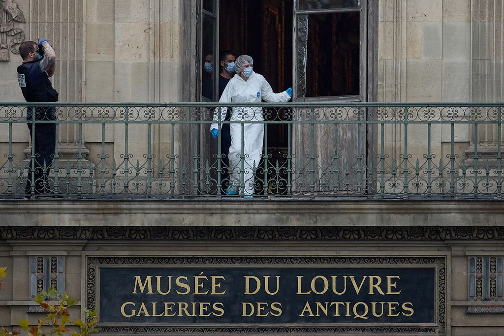 Un agente forense inspecciona la ventana forzada de la Galería Apolo del Museo del Louvre, escenario del robo de varias joyas históricas pocas horas después de su apertura al público.