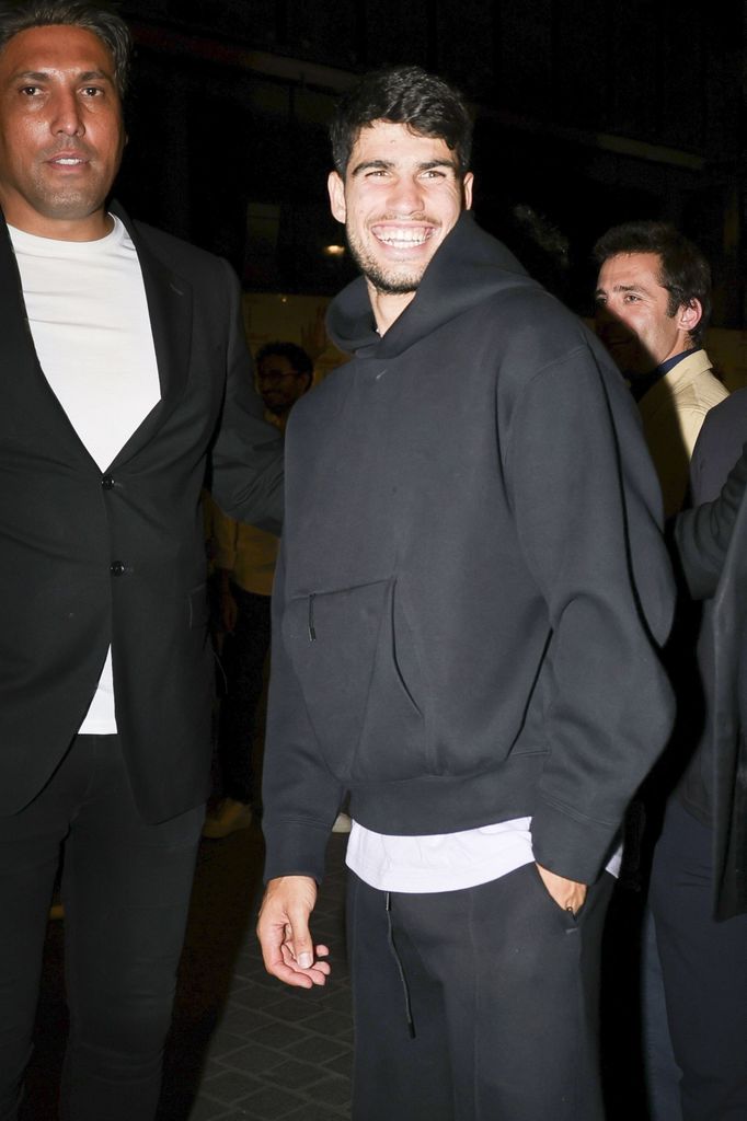 Carlos Alcaraz sonriente saliendo del restaurante Siena donde celebrar su triunfo en Rolan Garros.