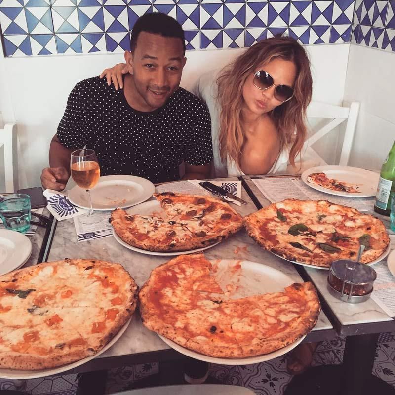 john leyend y crhirssy teigen comiendo pizza
