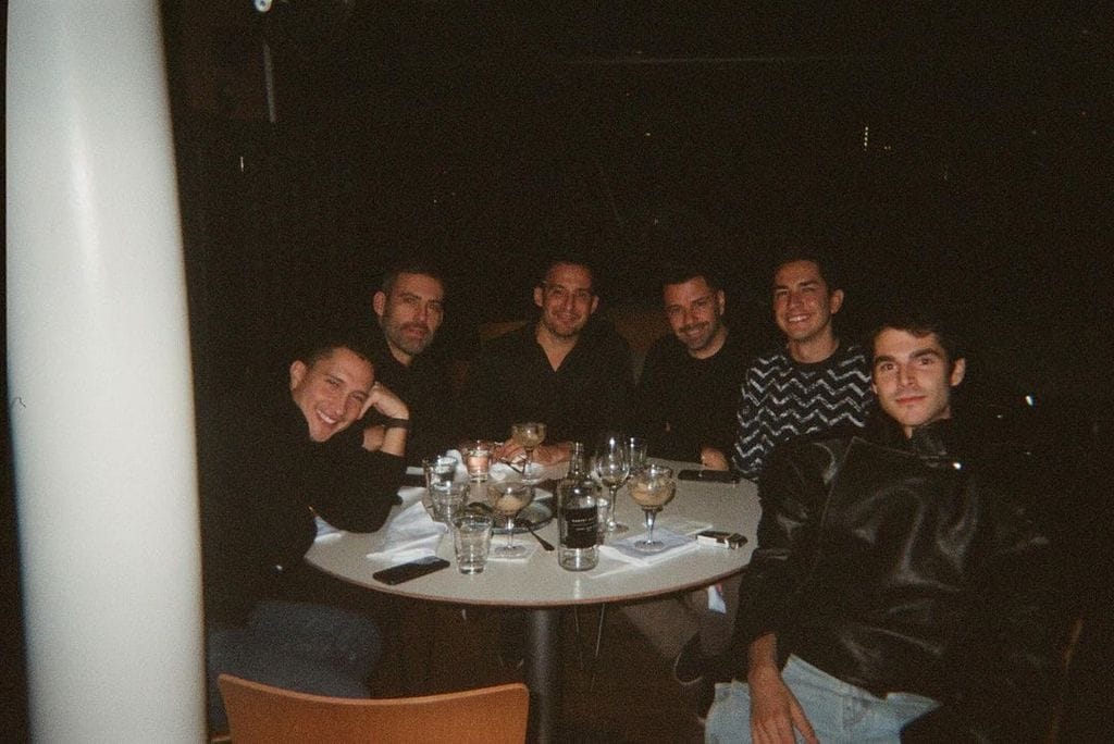 Plano medio de Álvaro Mel posando con unos amigos en un restaurante