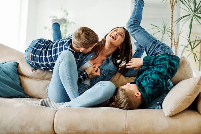mujer con sus hijos en el sofá