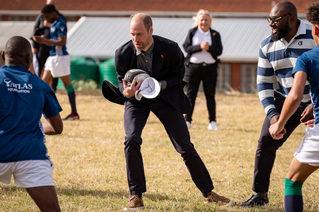 Plano medio del Principe Guillermo jugando al rugby en su visita a Sudafrica