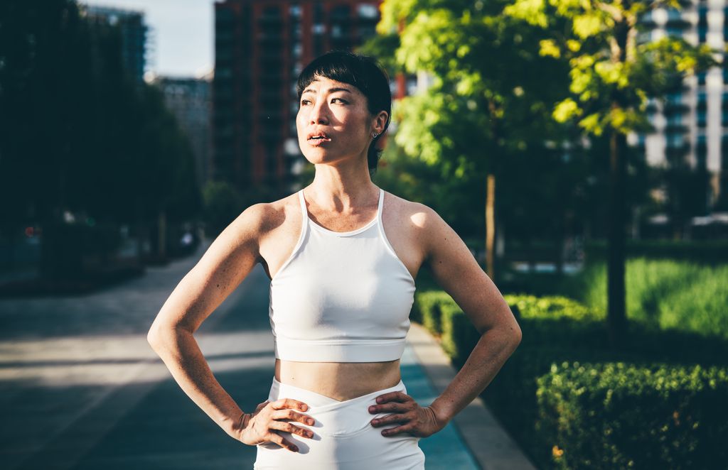 Mujer asiática en ropa deportiva en una pausa en su entrenamiento
