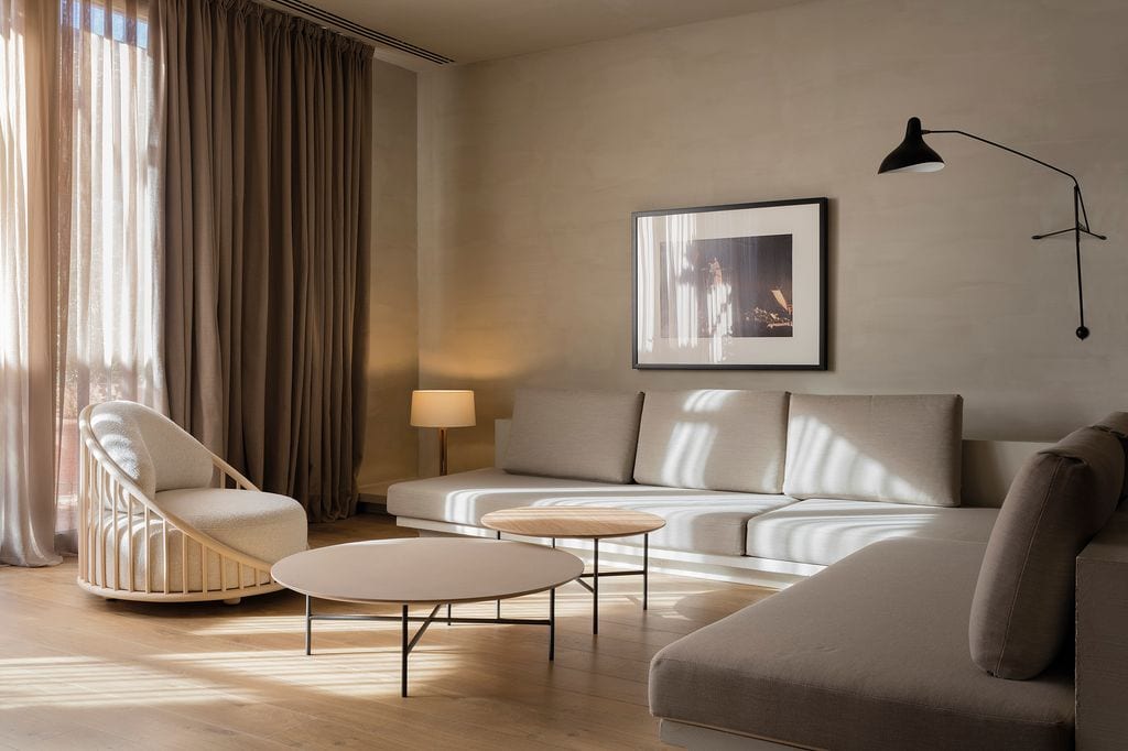 Salón con sofá en L y dos mesas de centro redondas